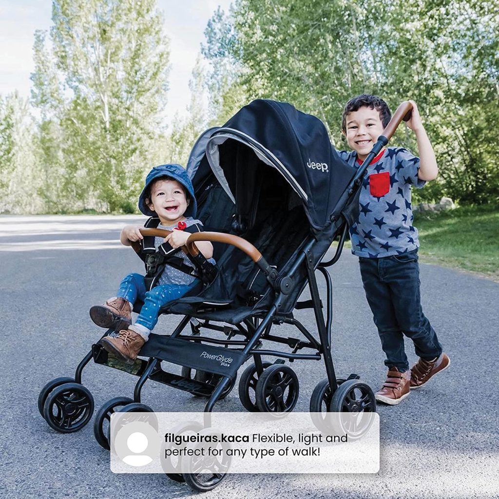 kid pushing toddler in double umbrella stroller